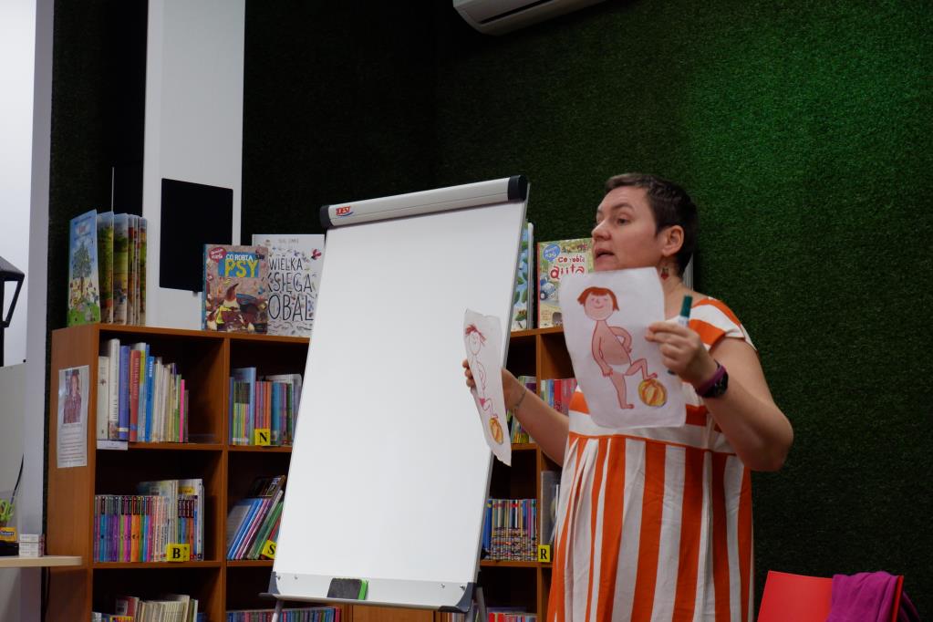Pisarka Zofia Stanecka przedstawia dzieciom na obrazku Basię-główną bohaterkę swoich książek